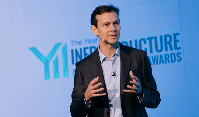 Nicholas Cumins, CEO of Bentley Systems, is speaking on stage in a suit in front of a backdrop with the text "Year in Infrastructure Awards.